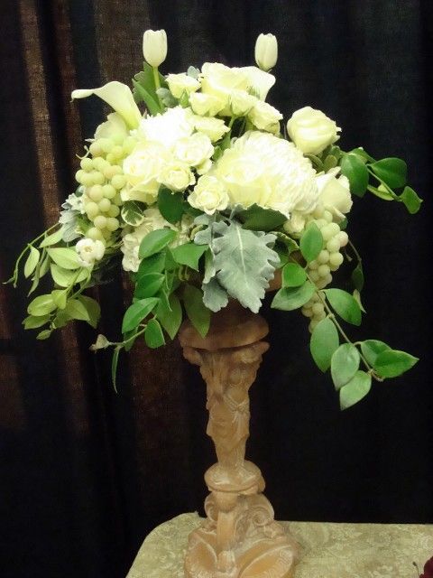 A vase filled with white flowers sits on a table