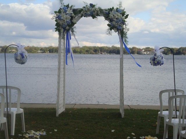 A wedding ceremony is taking place in front of a lake