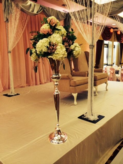 A vase filled with flowers sits on a stage