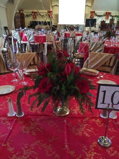 A table with a vase of red flowers and a table number 10
