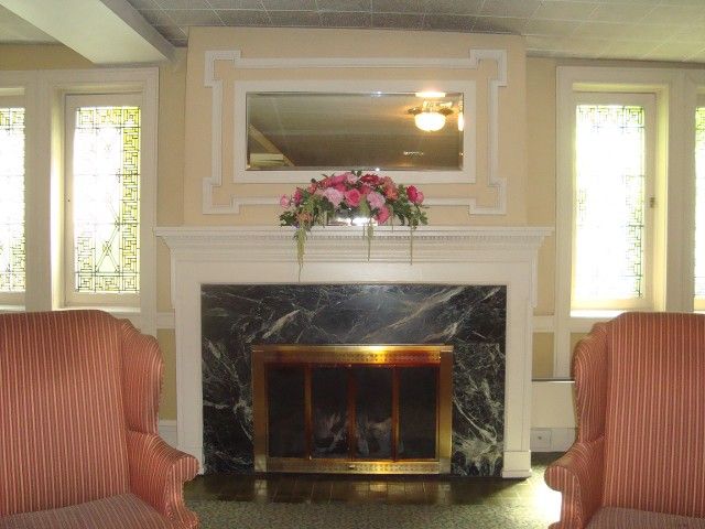 A living room with a fireplace and two chairs