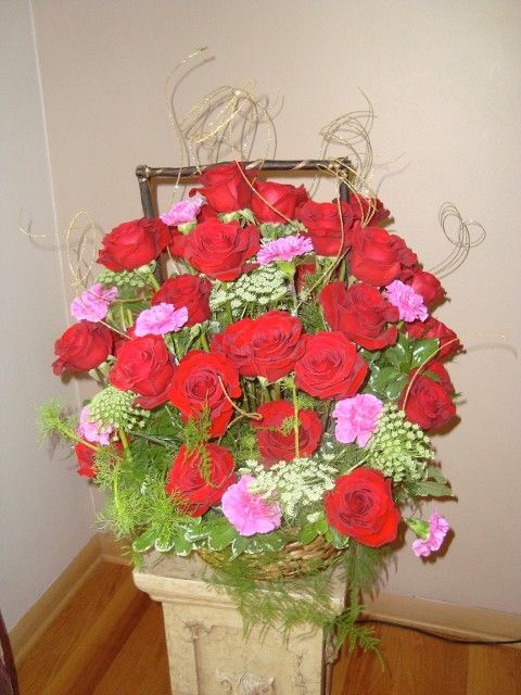A basket filled with red roses and pink carnations