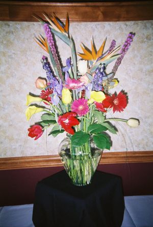 A vase filled with flowers sits on a table