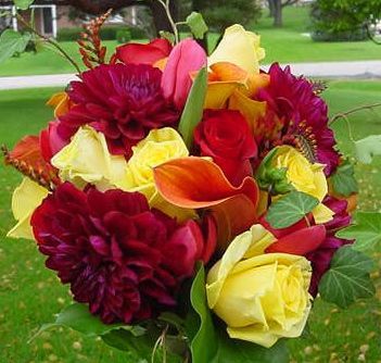 A bouquet of flowers including yellow roses and red dahlias
