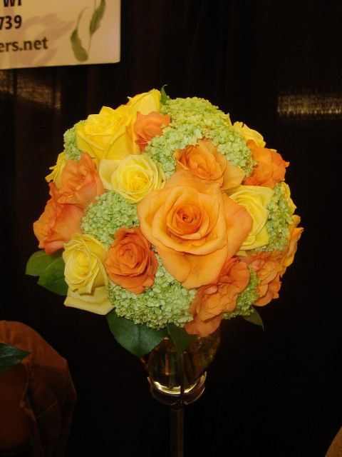 A bouquet of yellow and orange roses in a vase