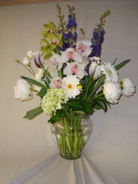A vase filled with purple and white flowers on a table