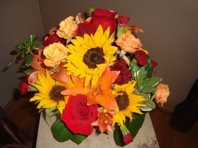 A bouquet of sunflowers and red roses on a table