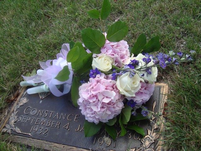 A gravestone with flowers on it that says constance september 4 1932