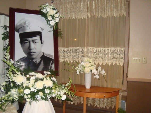 A picture of a man in a chef 's hat is surrounded by white flowers