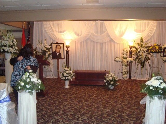 A woman stands in front of a podium with a picture of a man on it