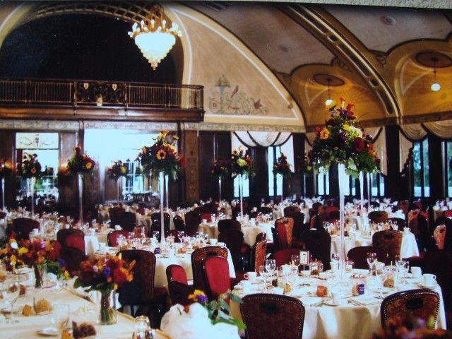 A large room with tables and chairs set up for a wedding reception