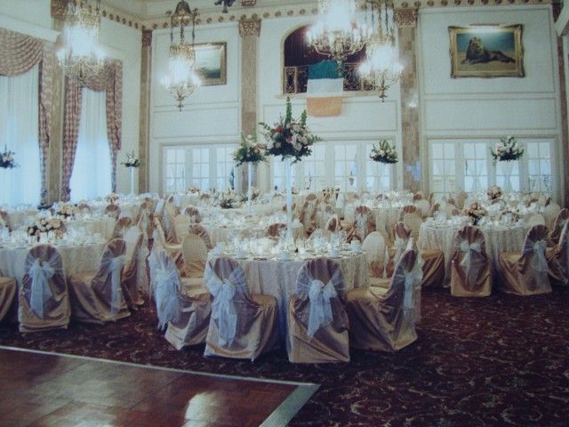 A large room with tables and chairs set up for a wedding reception
