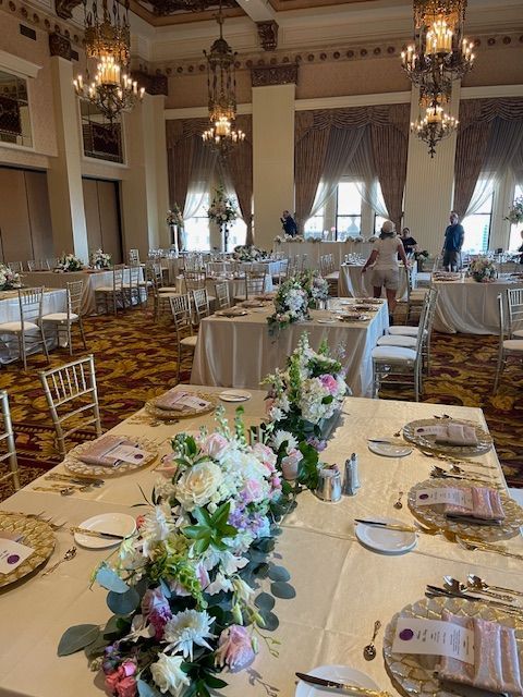 A large room with tables and chairs set up for a wedding reception.