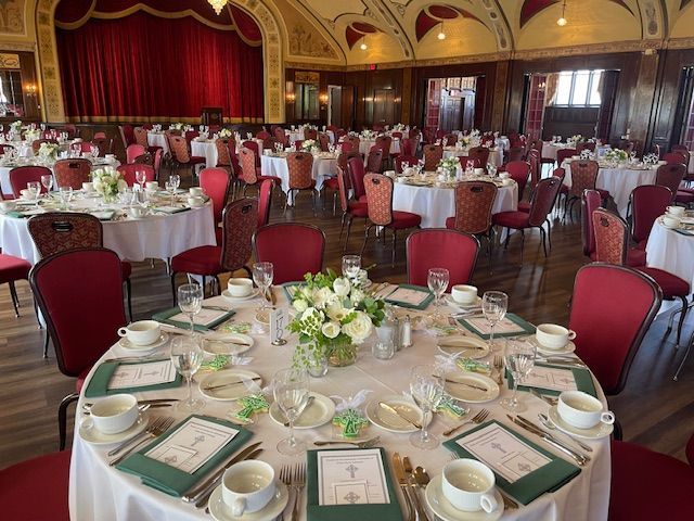 A large room with tables and chairs set up for a wedding reception
