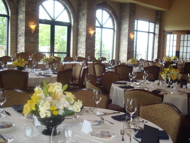 A large room filled with tables and chairs with flowers on them