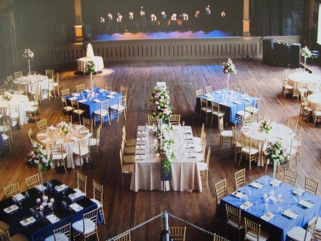 A large room with tables and chairs set up for a wedding reception