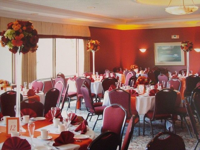 A large room with tables and chairs set up for a wedding reception