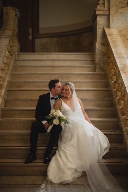 A vase filled with purple and white flowers sits on a table