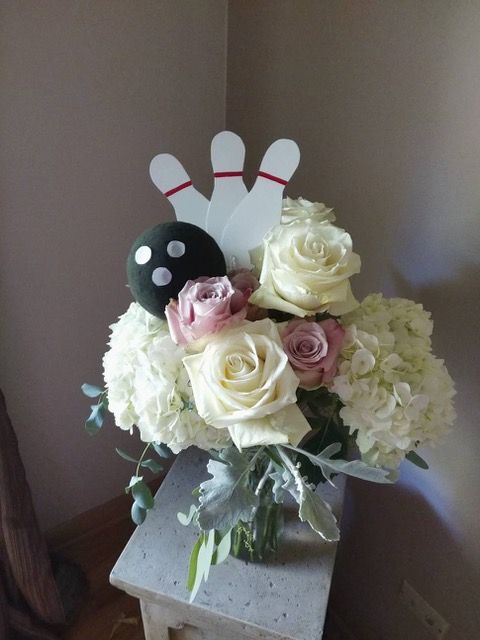 A bowling ball is sitting on top of a vase of flowers