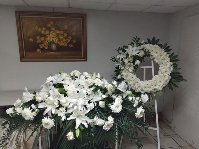 A wreath and a display of white flowers in a room.