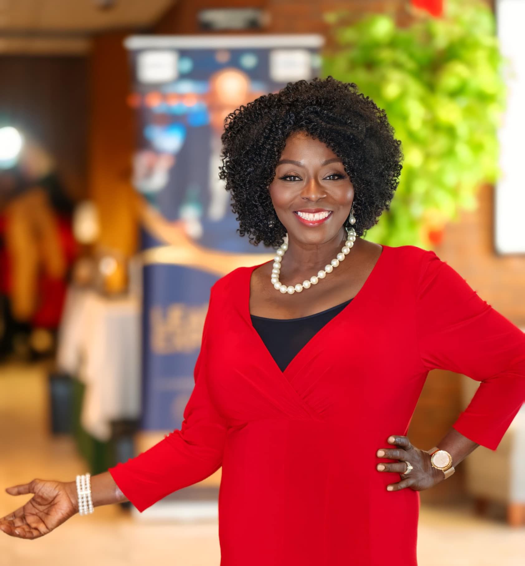 A woman wearing a red sweater and a pearl necklace