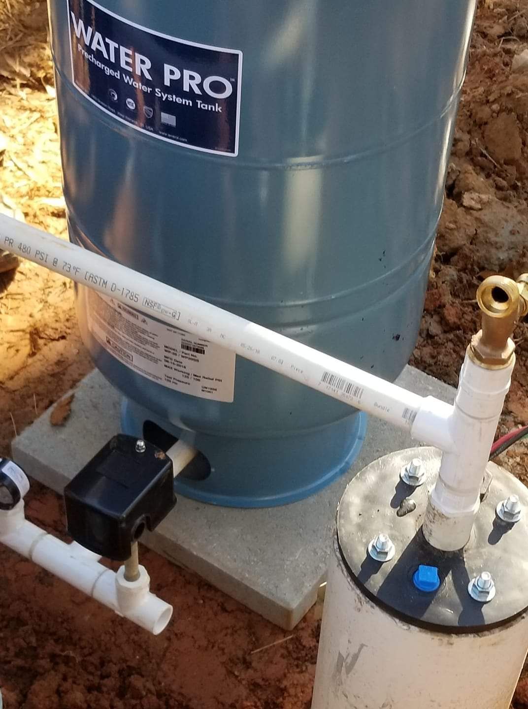 A water pro tank is sitting on top of a concrete base.