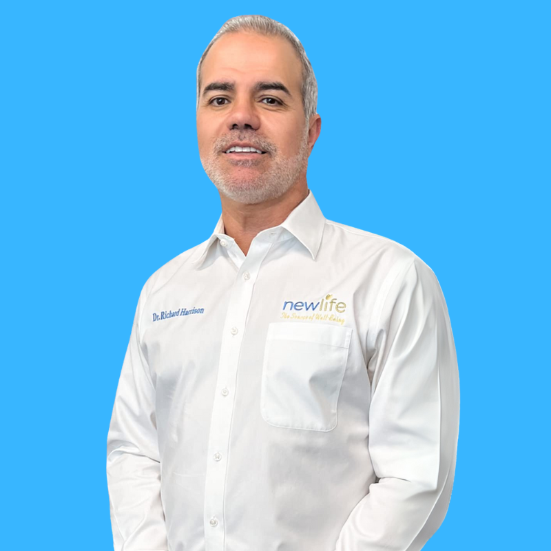 A man in a white shirt is standing in front of a blue background.