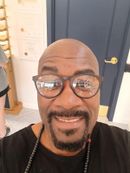 A man with glasses and a beard is smiling for the camera.