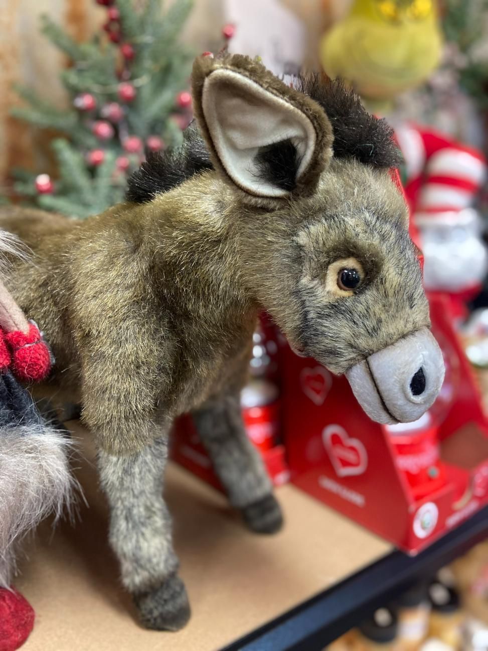 A Snowman is Sitting on a Christmas Ball Holding a Gift Box — Nambour Heights Gifts & Christmas Shop in Nambour, QLD