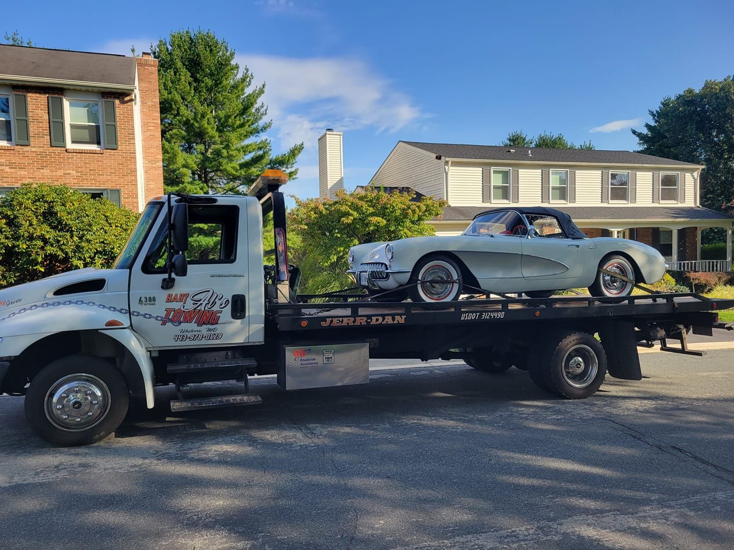 a tow truck with a car on the back of it