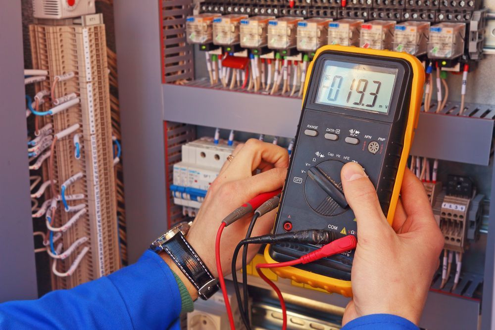 Electrician Using a Multimeter to Check Voltage in an Electrical Panel — AJW Electrical & Solar in Roma, QLD
