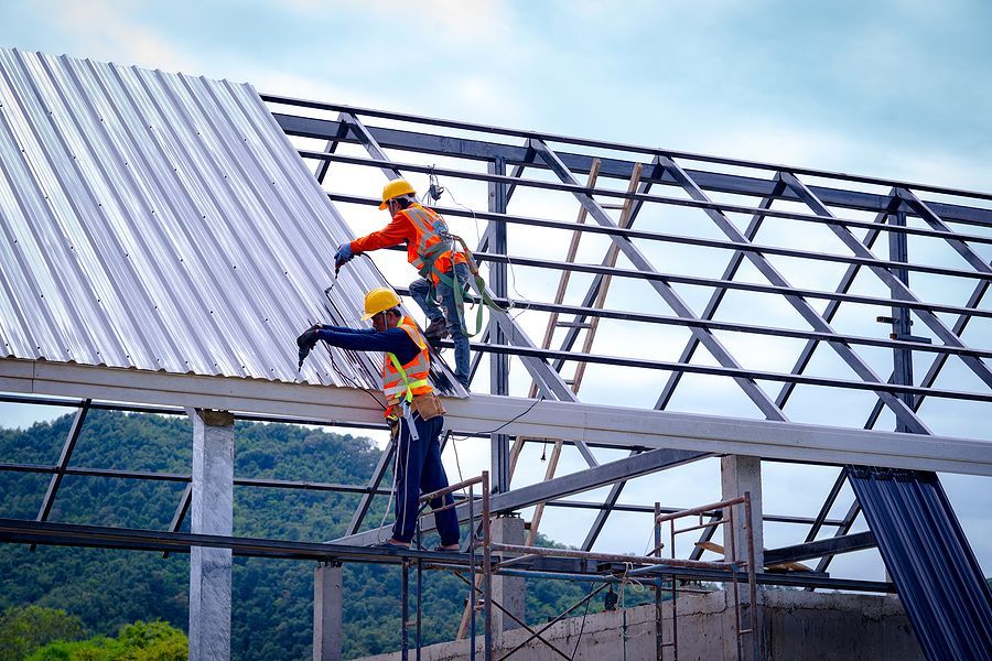 a couple of men standing on top of a metal roof