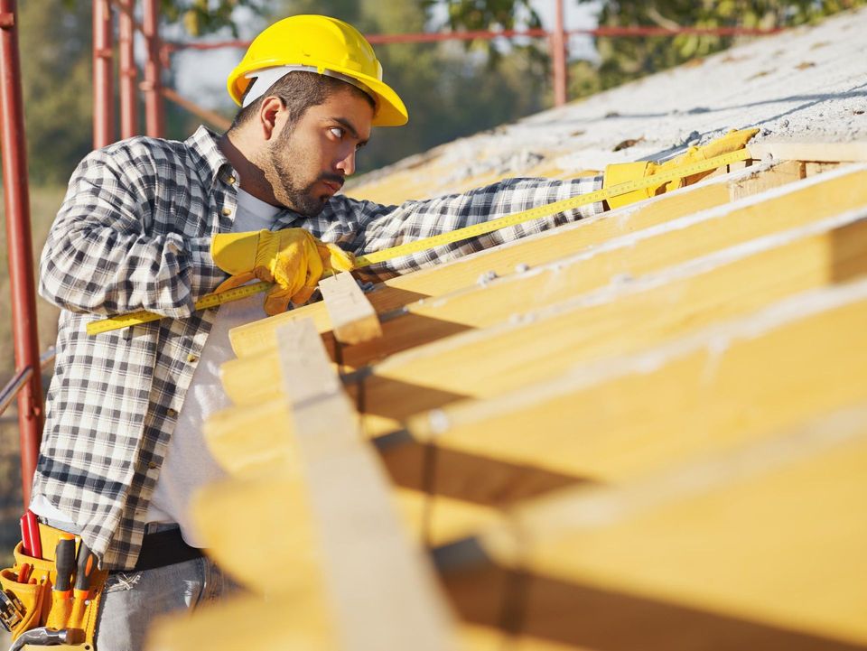 a man wearing a hard hat and yellow safety gloves