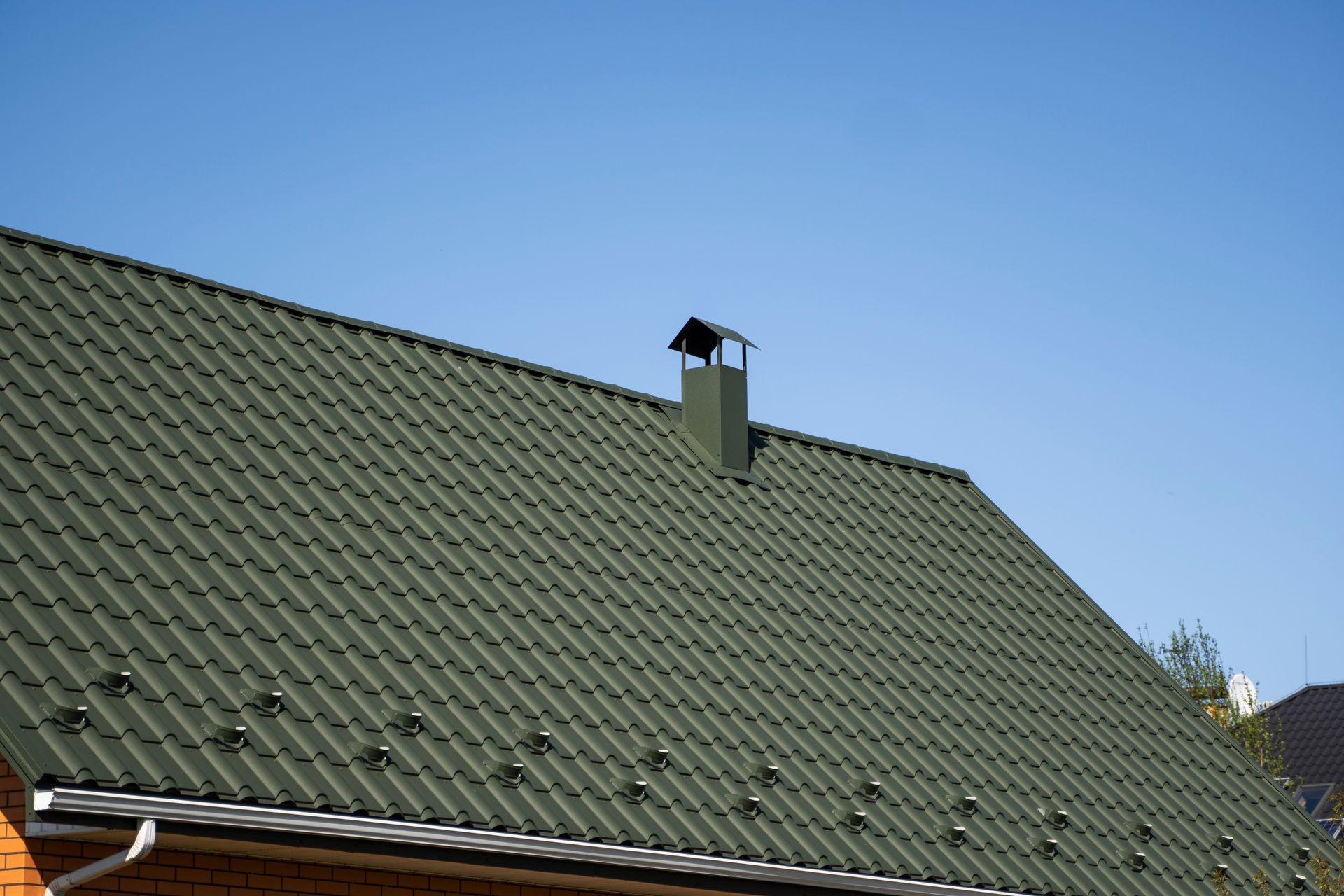 a couple of men standing on top of a metal roof