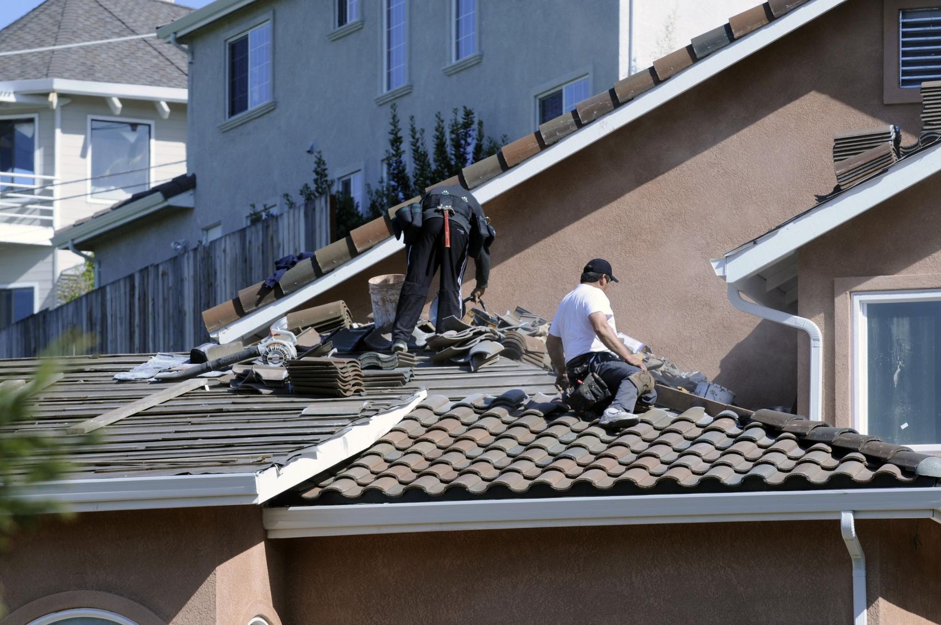 a couple of men working on a roof