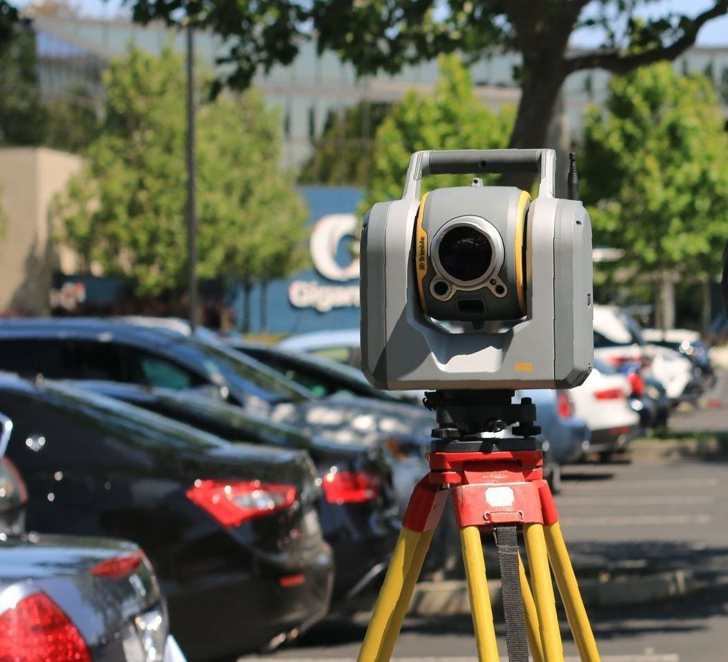 A camera is sitting on a tripod in a parking lot
