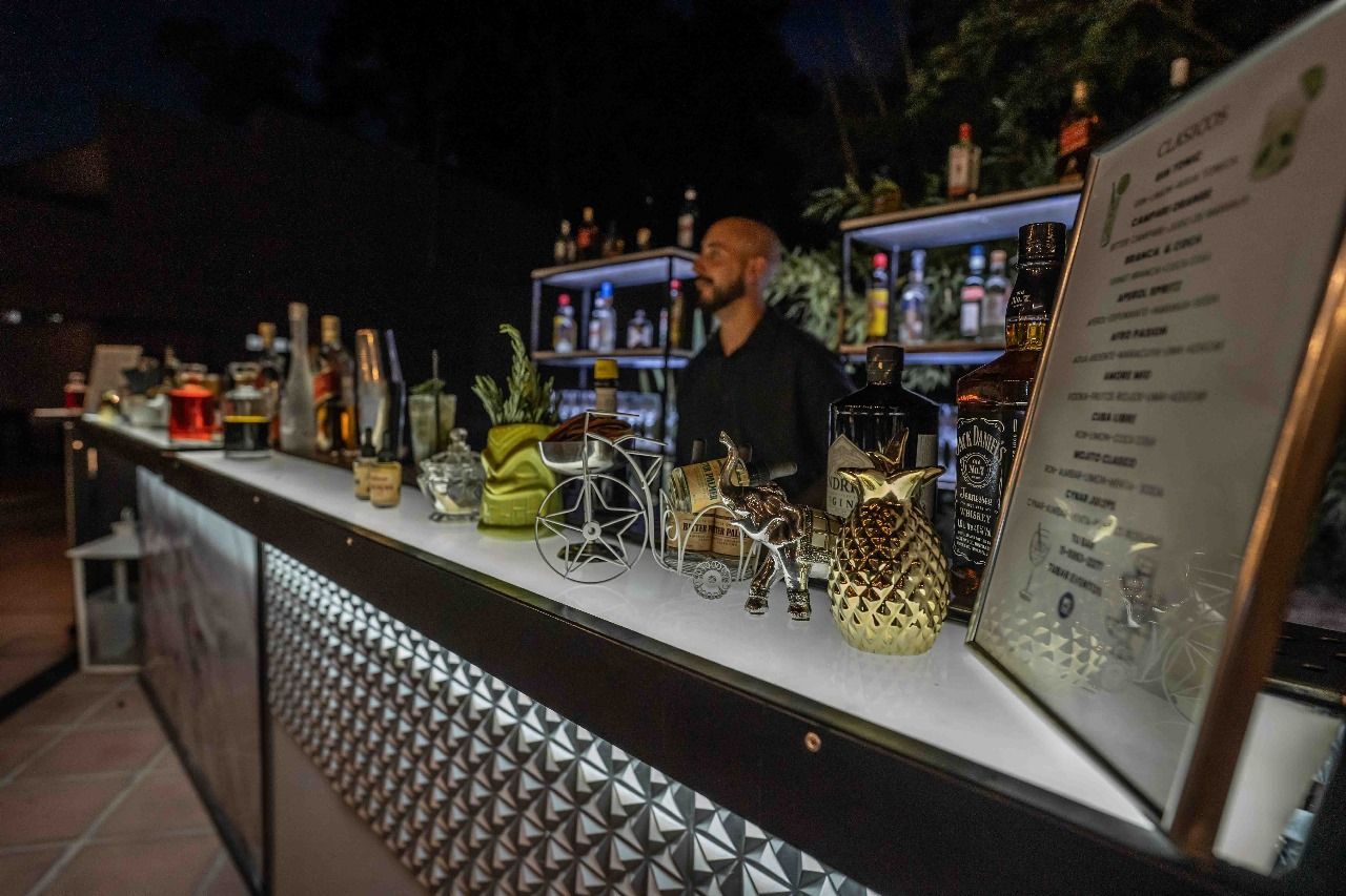 Un hombre está parado detrás de una barra con un menú en ella.