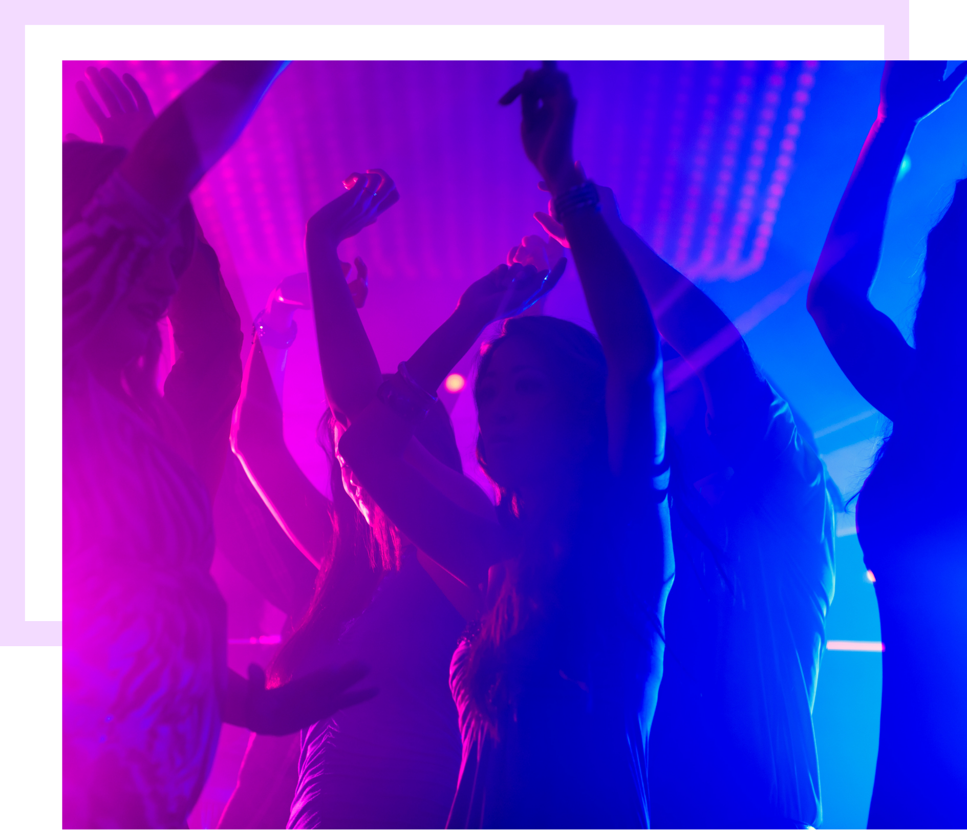 Des personnes dansent sous des lumières violettes et bleues dans une boîte de nuit.