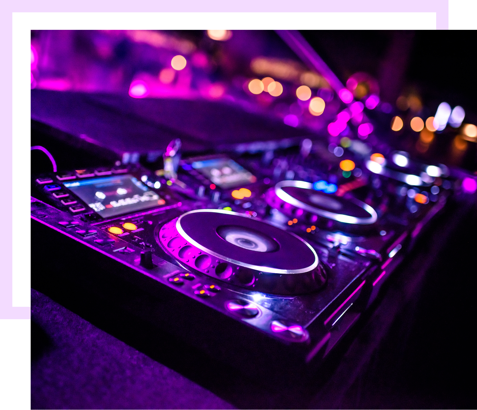 Table de mixage DJ illuminée en violet, décor avec lumières floues en arrière-plan.