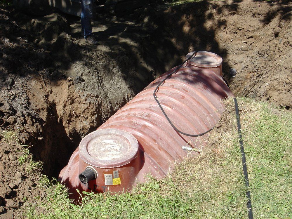 a septic tank is sitting in the dirt with a hose attached to it