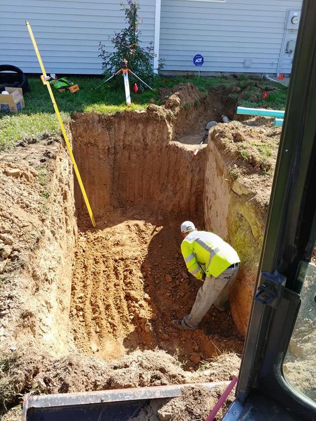 a man is digging a hole in the ground in front of a house .