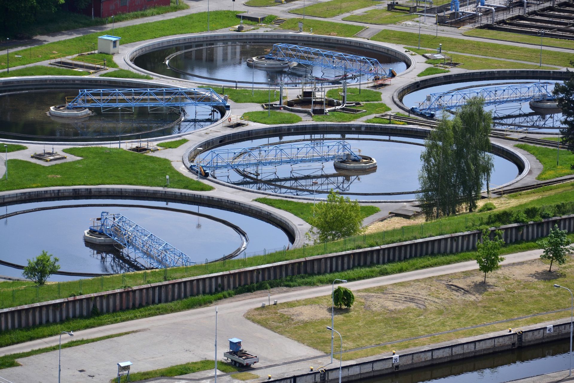 an aerial view of a sewage treatment plant with a lot of tanks filled with water .