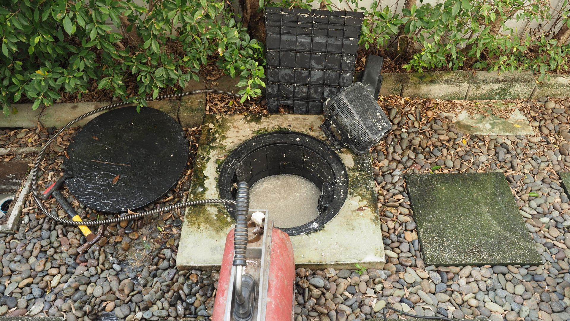 a manhole cover is being removed from a septic tank .