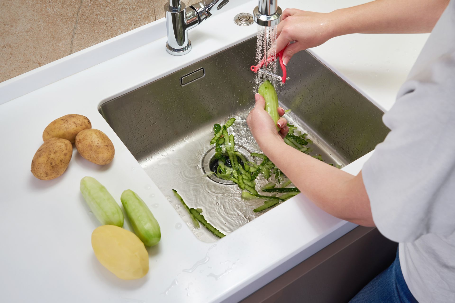 a person is washing vegetables in a kitchen sink .