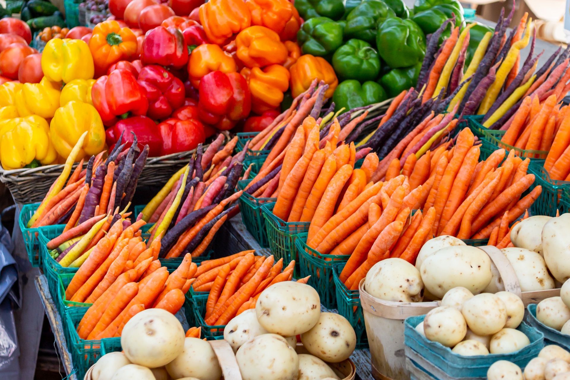 A table topped with baskets of potatoes and green beans.