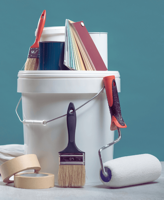 paint bucket, paint brush and paint swatches in a teal painted room