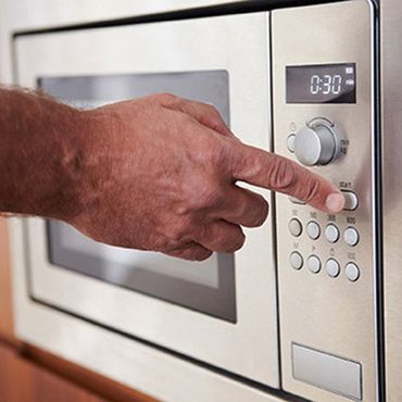 Home Appliance Repair — Man Using Microwave in Bountiful, UT