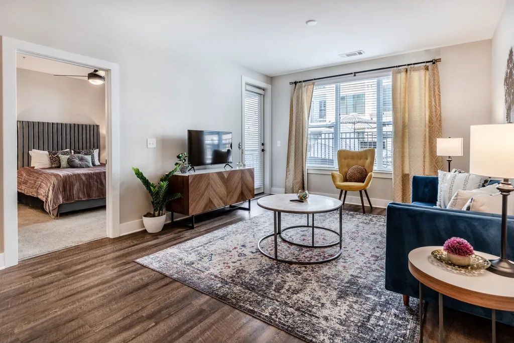 A living room with a couch , chair , coffee table and television.