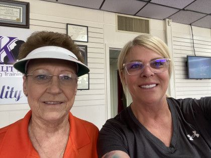 Two women are posing for a picture together in a room.