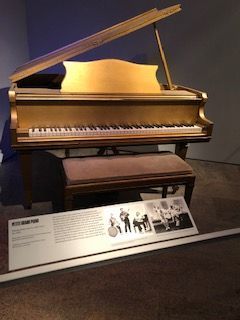 A grand piano is on display in a museum.